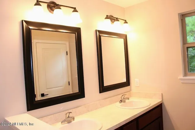 a bathroom with a sink a mirror and a shower