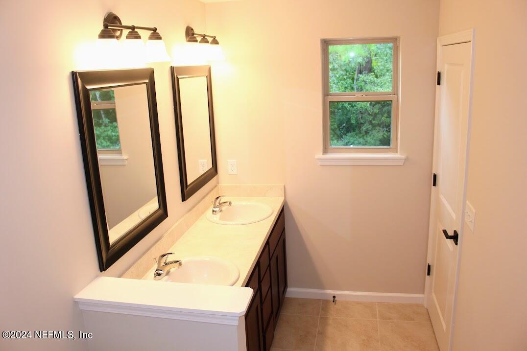 4148 Quiet Creek Loop, Unit 132 Middleburg, FL 32068 - Photo 27 of 42 a bathroom with a sink a mirror and a shower