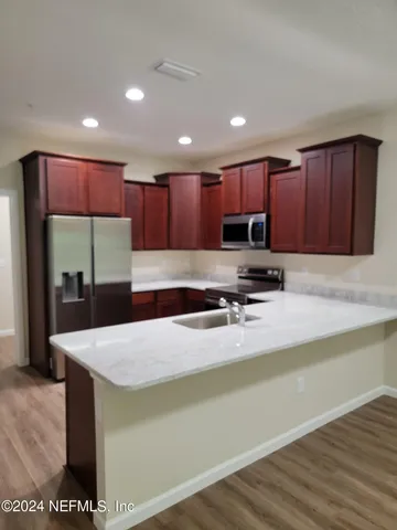 a kitchen with stainless steel appliances granite countertop a sink refrigerator and cabinets