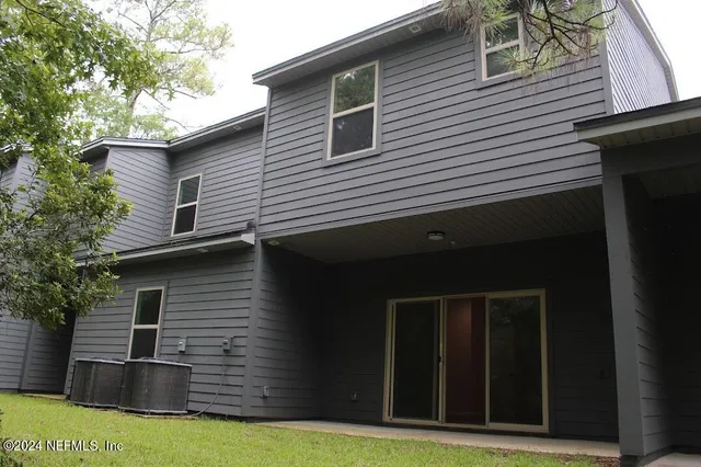 a view of a yard with plants and tree