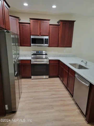 a kitchen with stainless steel appliances granite countertop a stove refrigerator sink and cabinets