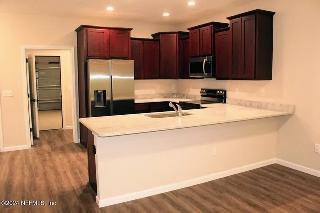 a kitchen with wooden cabinets a sink and a refrigerator