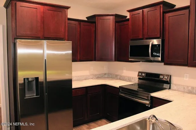 a kitchen with granite countertop stainless steel appliances and wooden cabinets