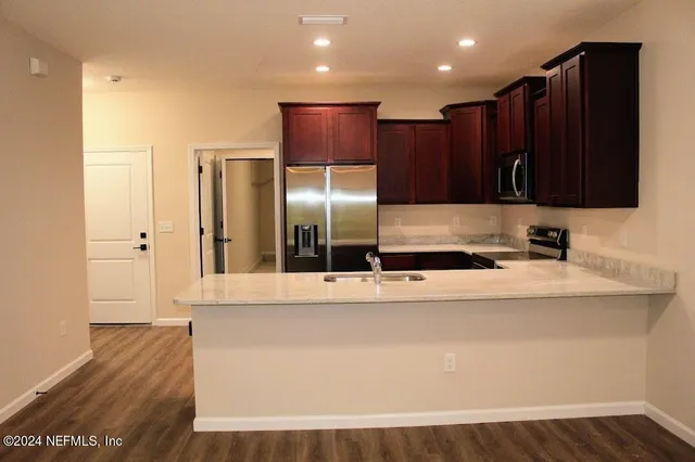 a large white kitchen with wooden floor