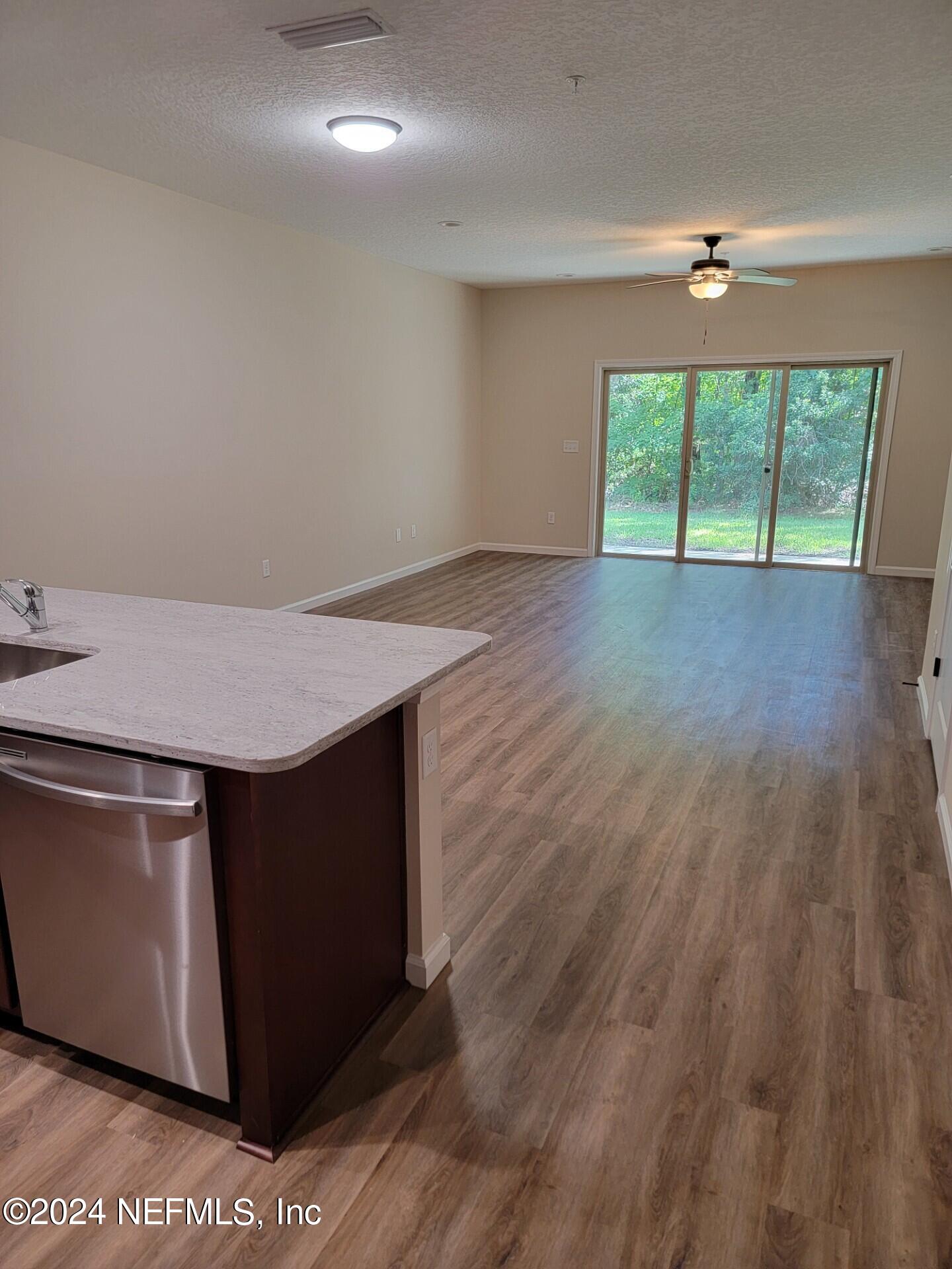 4148 Quiet Creek Loop, Unit 132 Middleburg, FL 32068 - Photo 9 of 42 an empty room with wooden floor and windows