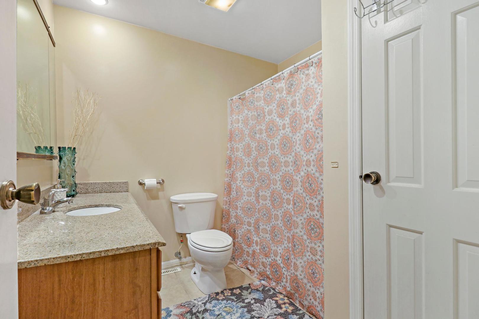 10254 West Beach Road Beach Park, IL 60099 - Photo 20 of 25 a bathroom with a granite countertop sink and a toilet