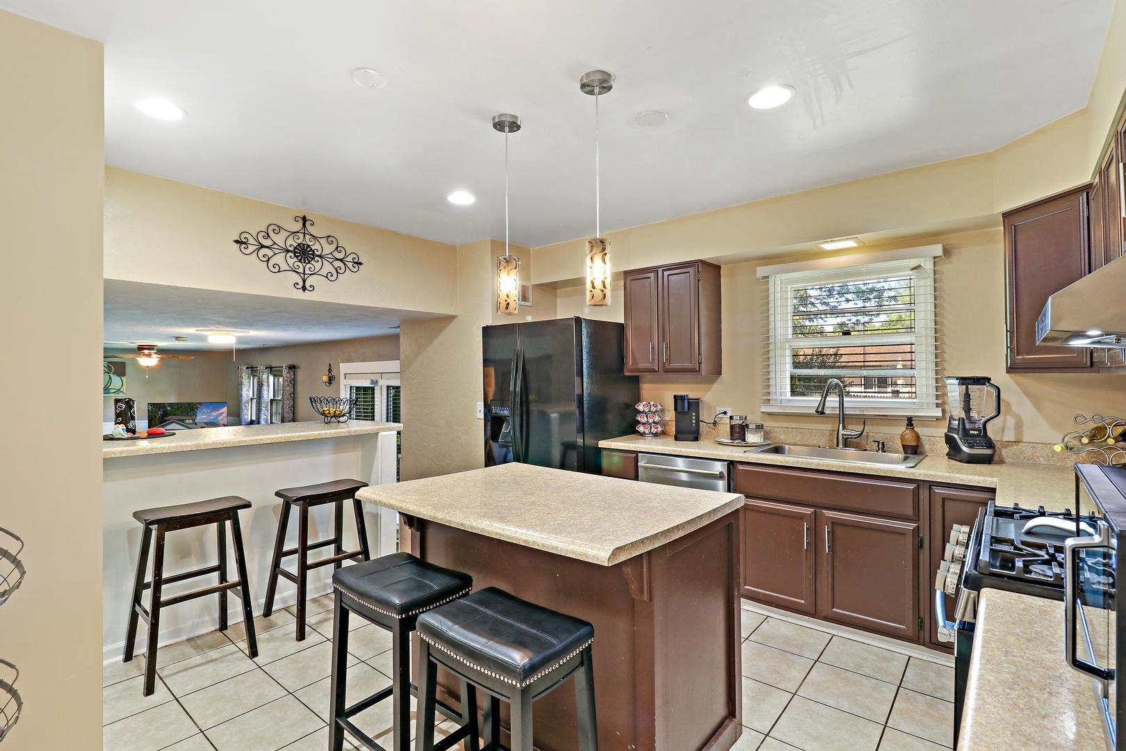 10254 West Beach Road Beach Park, IL 60099 - Photo 5 of 25 a kitchen with a sink a stove a refrigerator and chairs