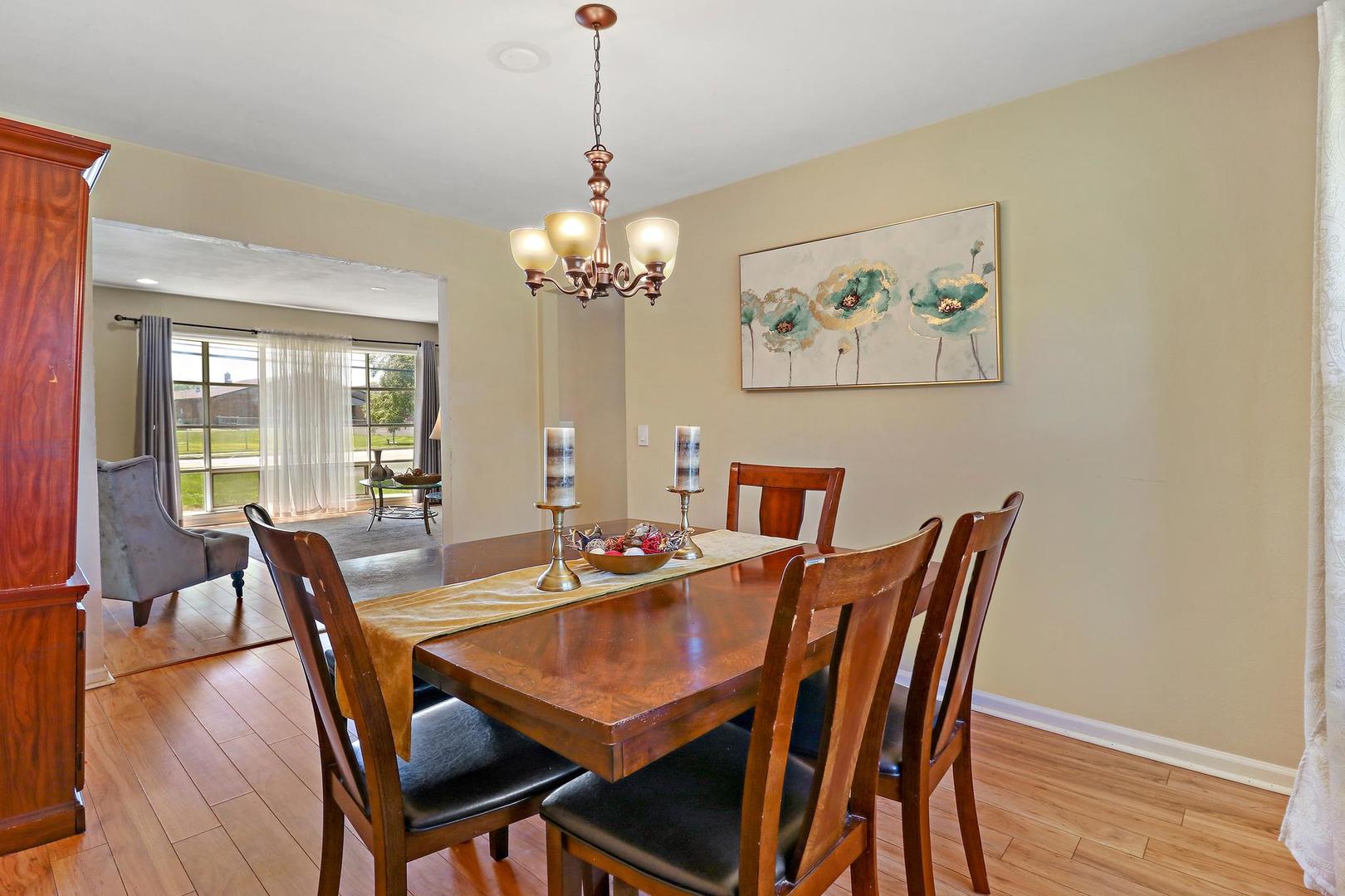 10254 West Beach Road Beach Park, IL 60099 - Photo 9 of 25 a view of a dining room with furniture wooden floor and chandelier
