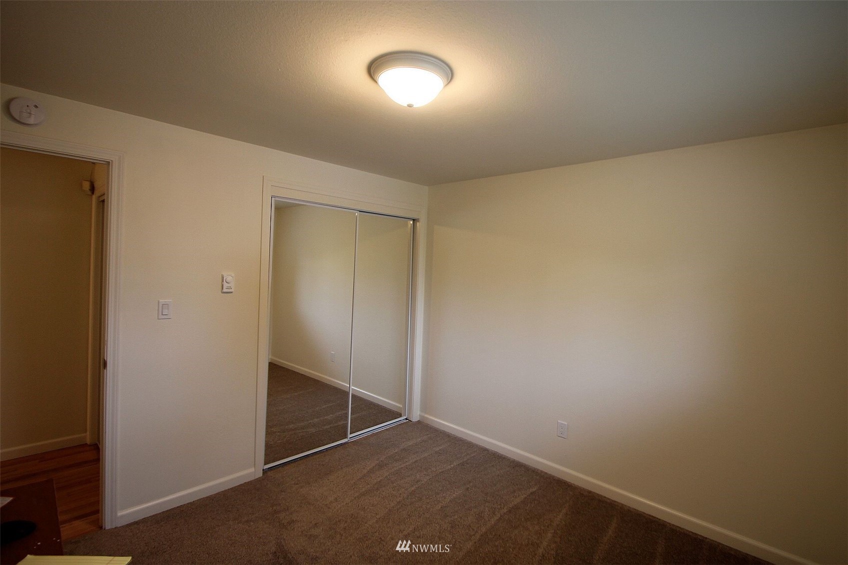 19504 Winesap Lane Bothell, WA 98012 - Photo 18 of 23 an empty room with a ceiling fan and wooden floor