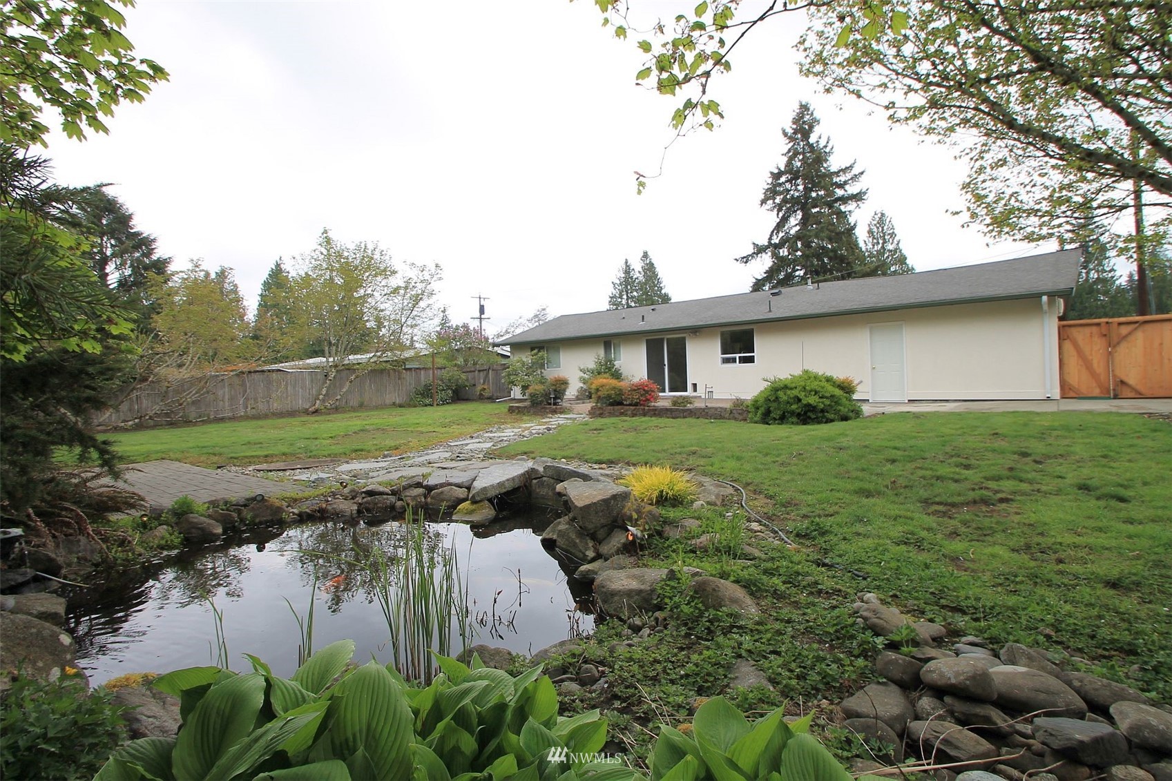 19504 Winesap Lane Bothell, WA 98012 - Photo 3 of 23 a view of a house with a big yard and large trees