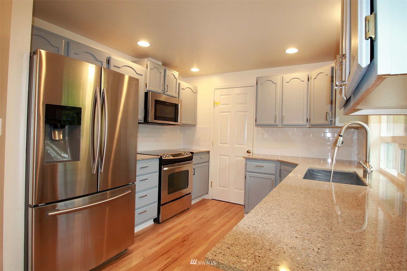 19504 Winesap Lane Bothell, WA 98012 - Photo 9 of 23 a kitchen with stainless steel appliances granite countertop a refrigerator stove and sink