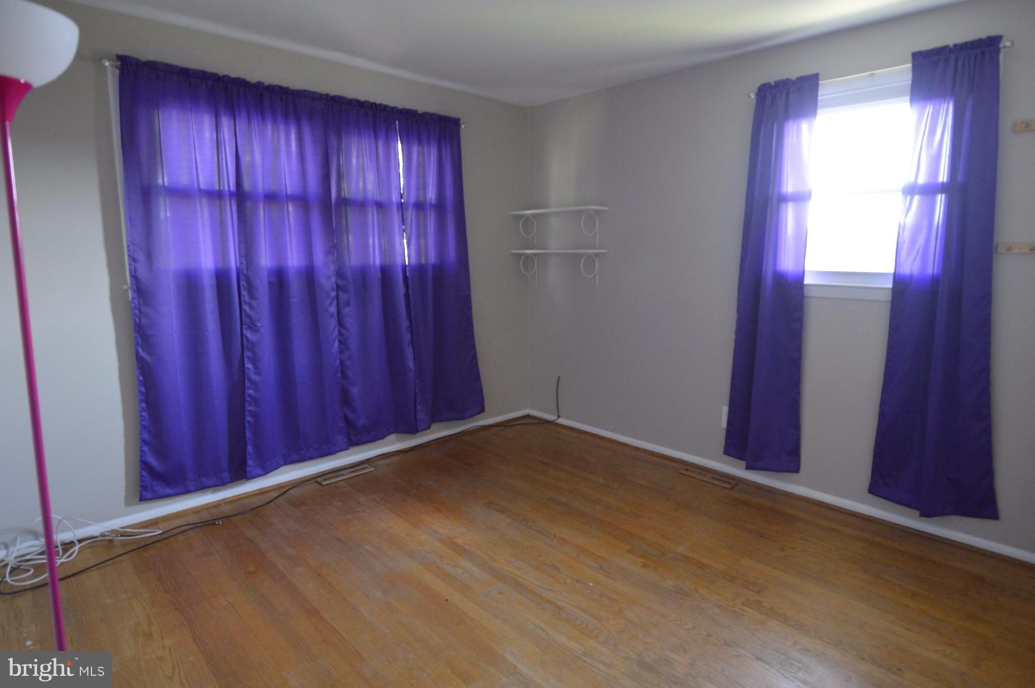 1730 Weyburn Road Baltimore, MD 21237 - Photo 11 of 25 an empty room with wooden floor and windows