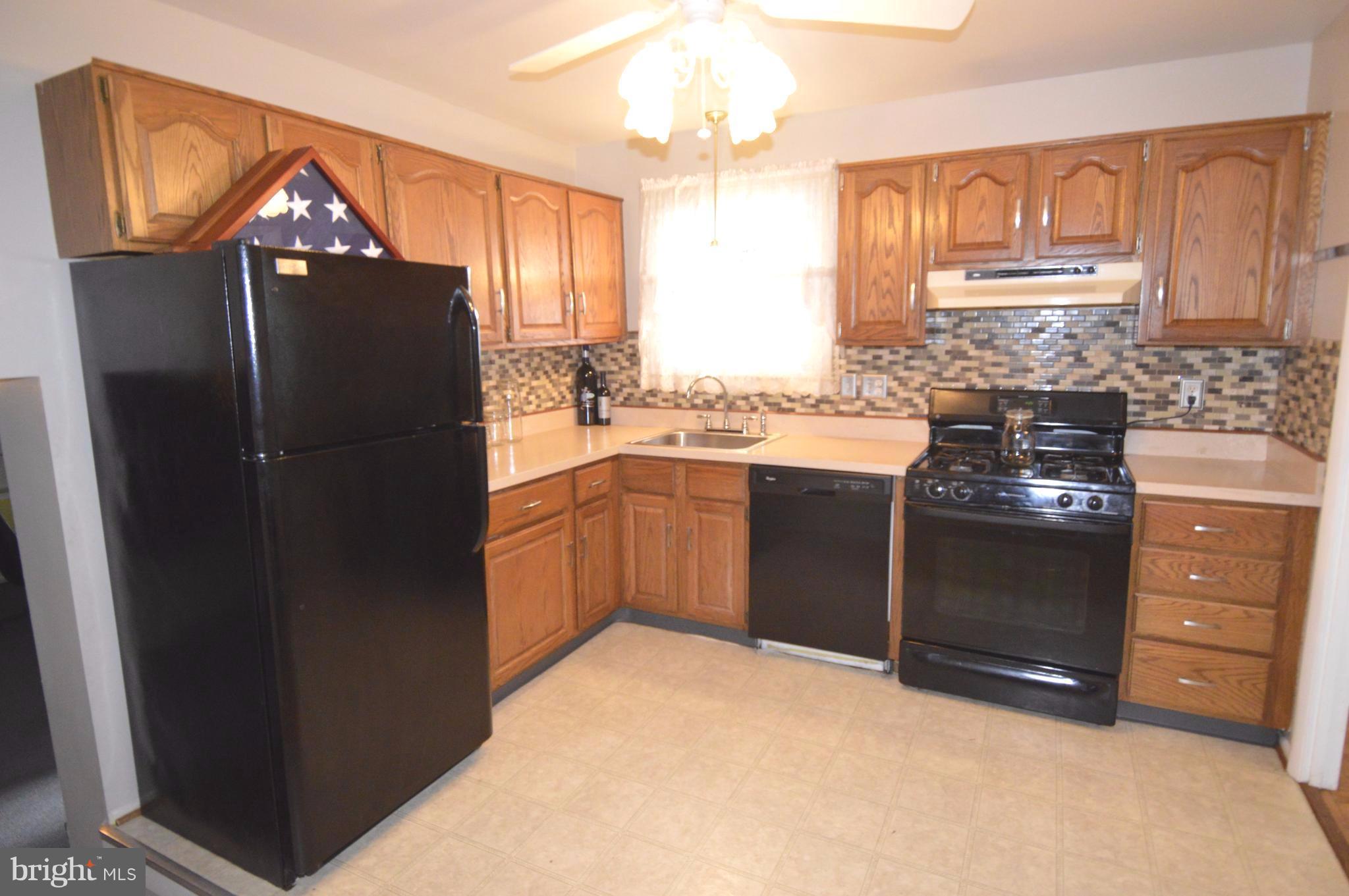 1730 Weyburn Road Baltimore, MD 21237 - Photo 3 of 25 a kitchen with a refrigerator and a sink