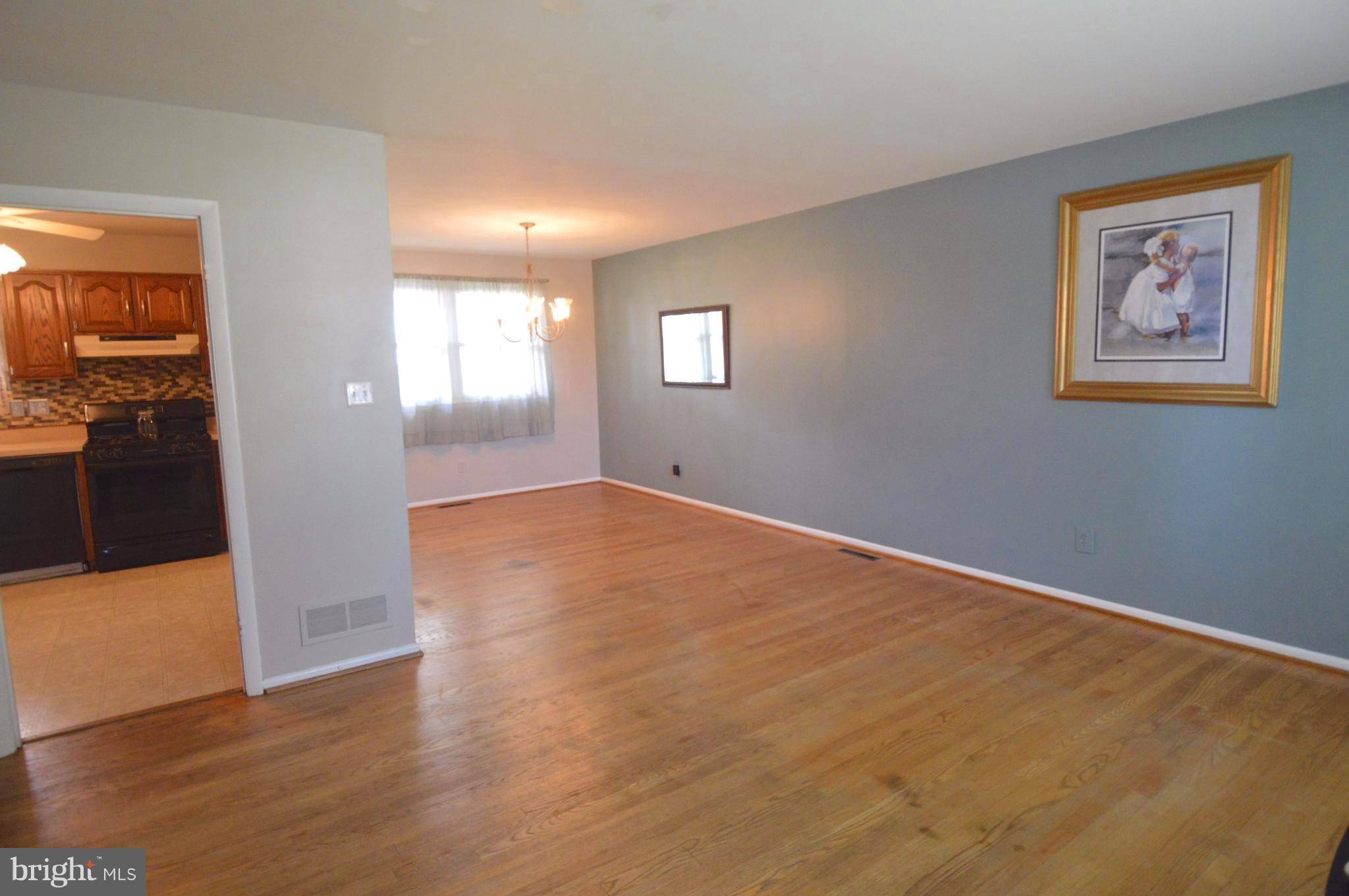 1730 Weyburn Road Baltimore, MD 21237 - Photo 5 of 25 an empty room with wooden floor and windows