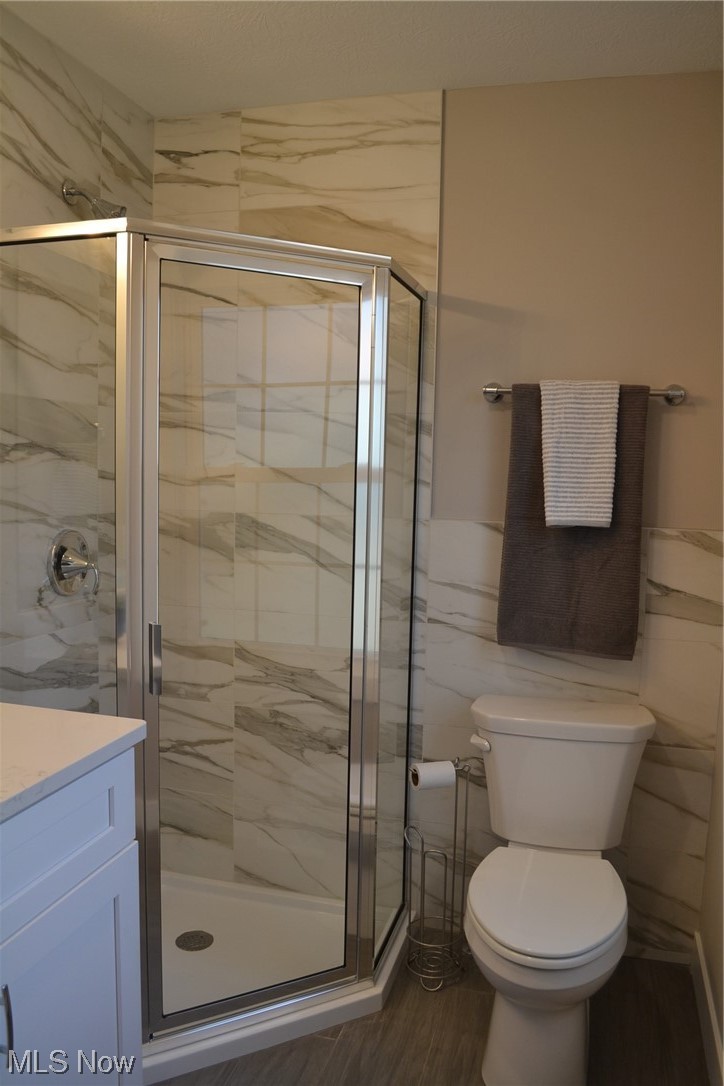 3693 Stoer Road Shaker Heights, OH 44122 - Photo 17 of 35 Bathroom featuring toilet, tile walls, hardwood / wood-style flooring, walk in shower, and vanity