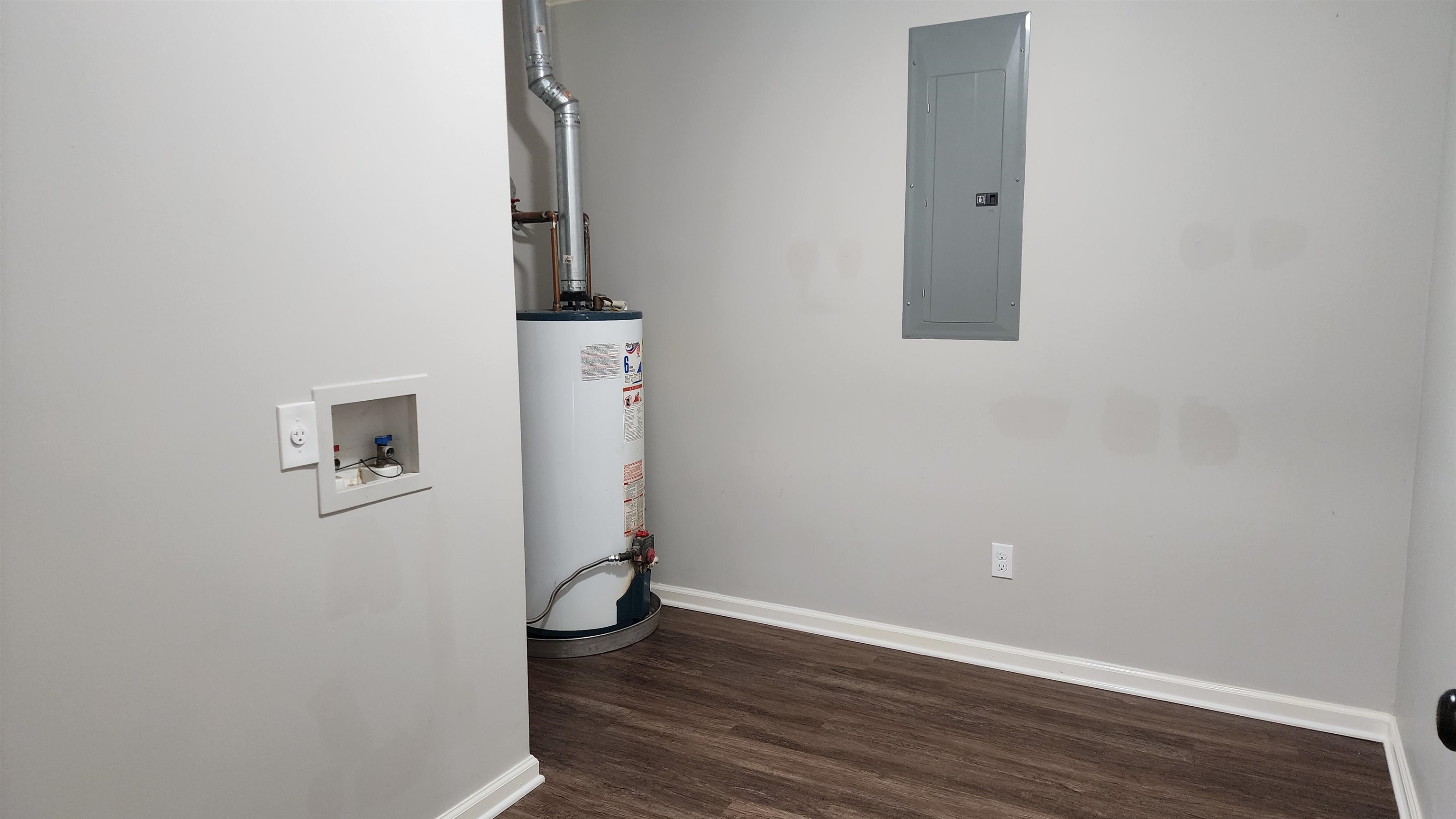 445 Caldwell Road Ripley, TN 38063 - Photo 11 of 14 Washroom with electric panel, water heater, hookup for a washing machine, wood finished floors, and baseboards