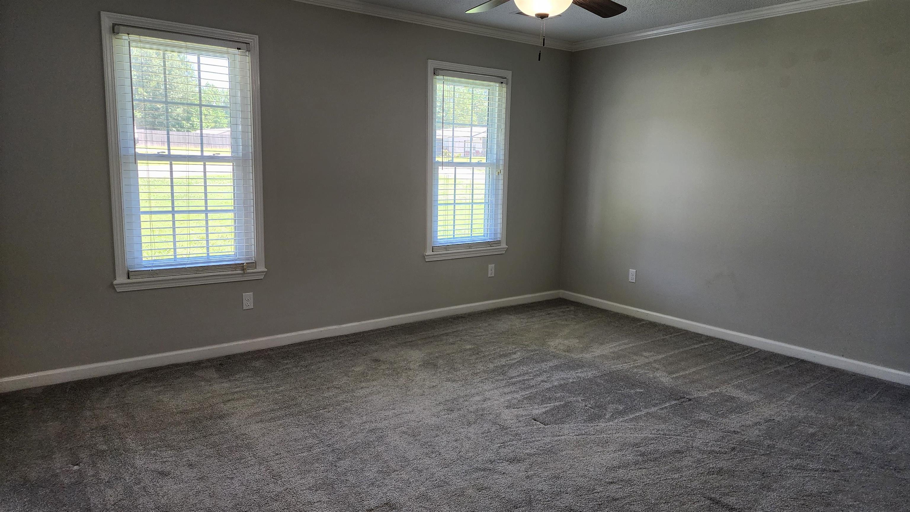 445 Caldwell Road Ripley, TN 38063 - Photo 6 of 14 Spare room with dark carpet, ceiling fan, baseboards, and crown molding