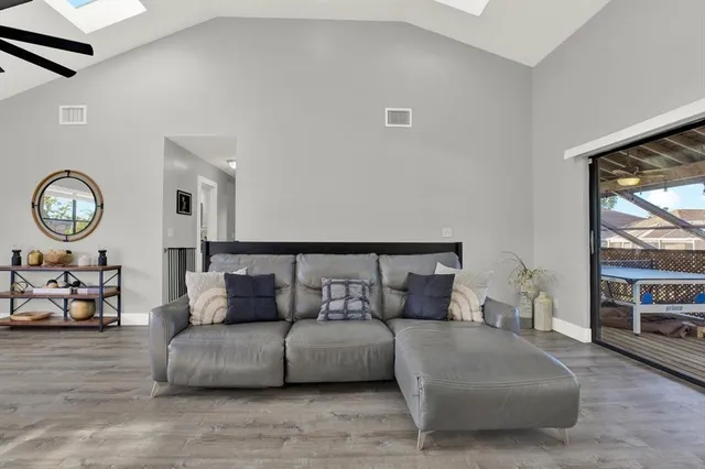 a living room with furniture a clock on wall and a window