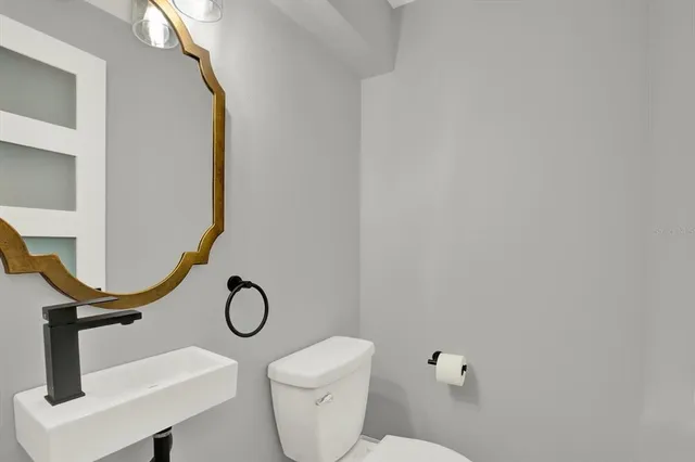 a en suite bathroom with a granite countertop sink and a mirror