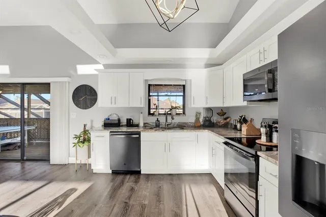 a kitchen with granite countertop a stove top oven microwave and cabinets