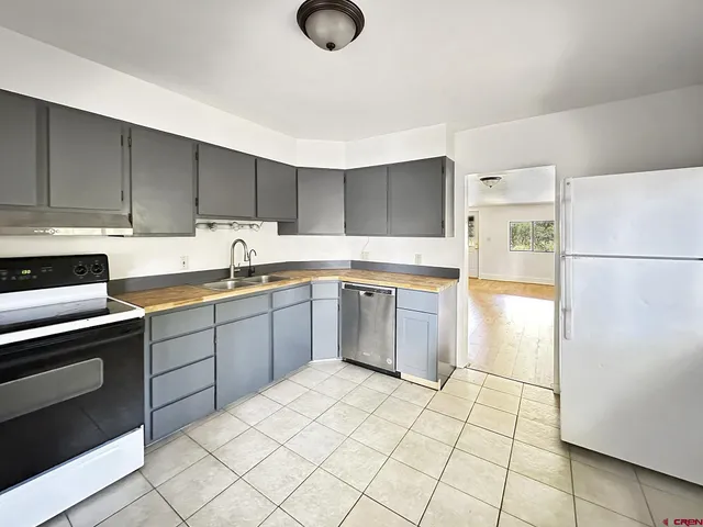 a kitchen with a sink a stove a refrigerator and cabinets