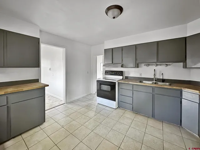 a kitchen with a sink a stove and cabinets