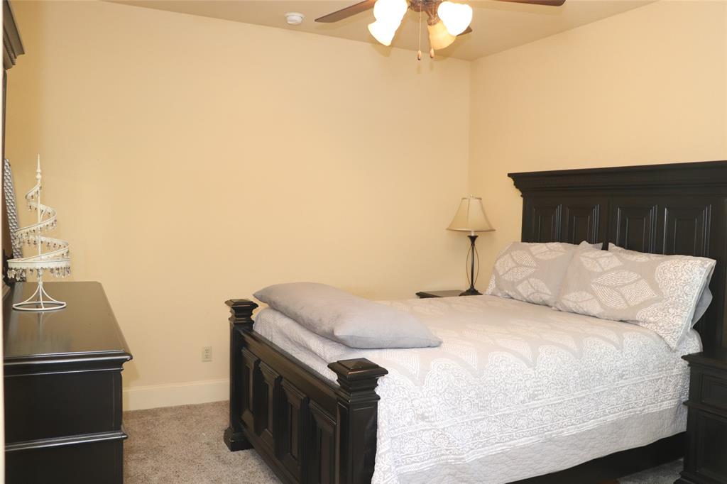 5614 Pleasant Ridge Road Dallas, TX 75236 - Photo 14 of 23 a bedroom with a bed and a chandelier