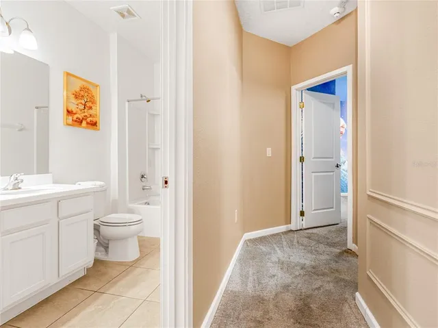 a en suite bathroom with a toilet a sink and a window