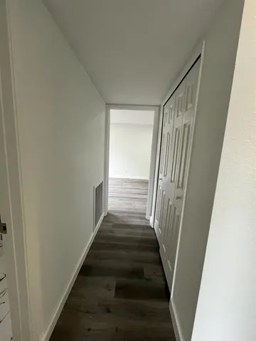 a view of a hallway with wooden floor