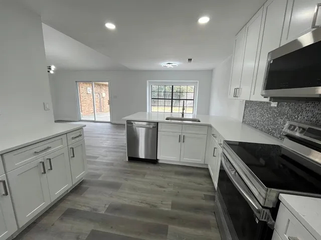 a kitchen with granite countertop a sink and a stove top oven