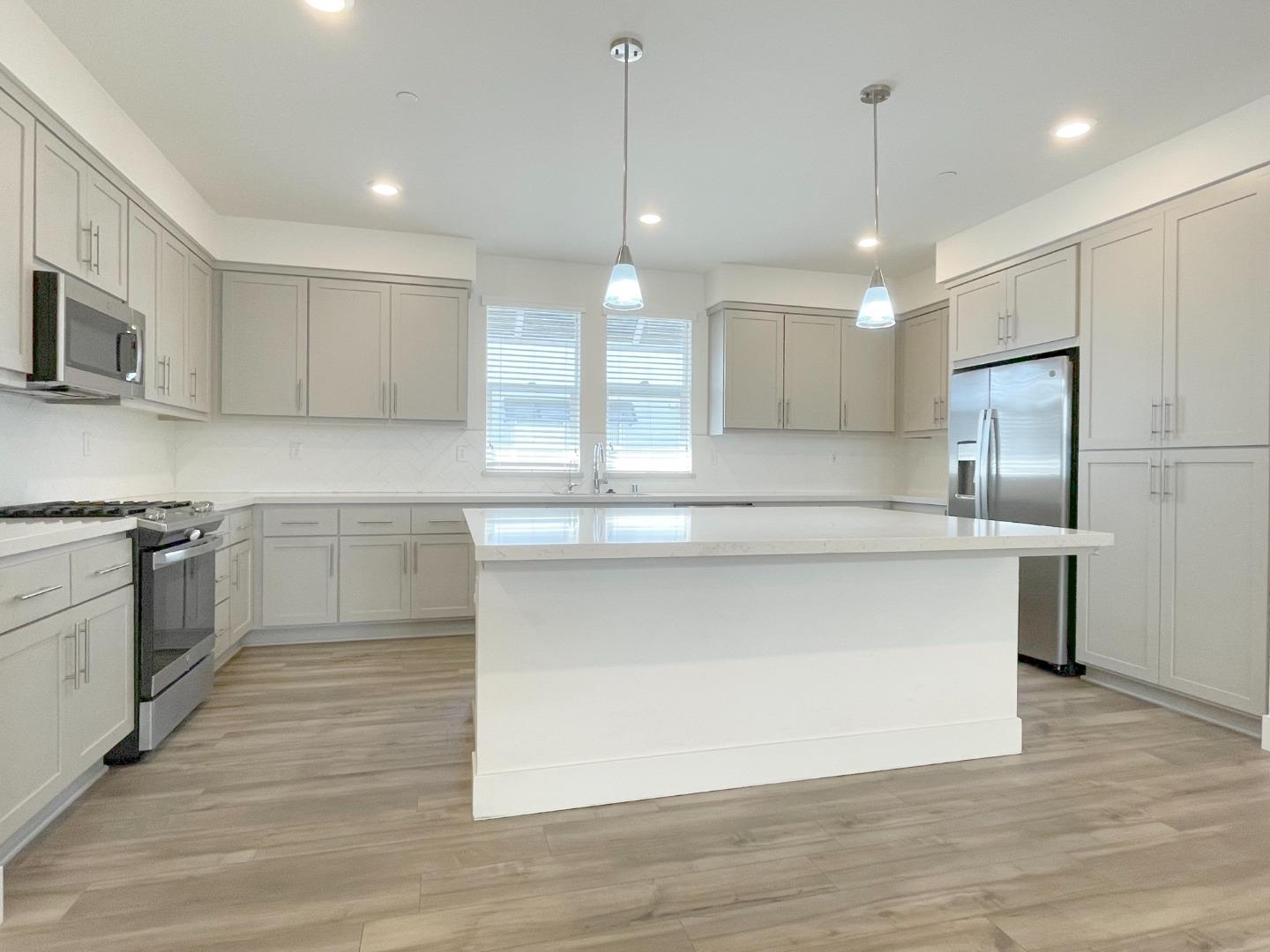 9600 Seawind Way Newark, CA 94560 - Photo 7 of 24 a kitchen with kitchen island a counter space a sink appliances and cabinets