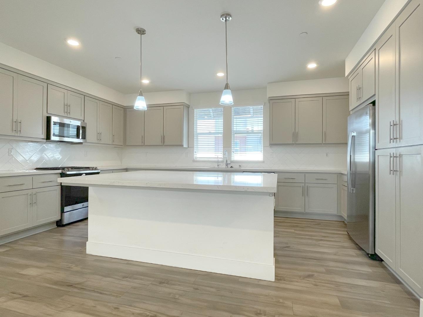 9600 Seawind Way Newark, CA 94560 - Photo 8 of 24 an open kitchen with kitchen island white cabinets and stainless steel appliances