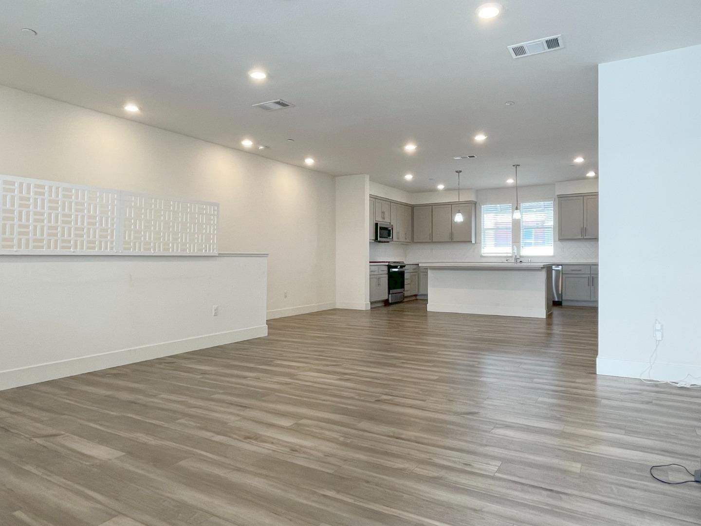 9600 Seawind Way Newark, CA 94560 - Photo 10 of 24 a view of kitchen with kitchen island a sink wooden floor and a refrigerator