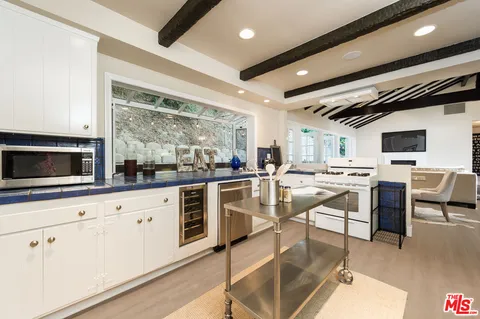 a kitchen with white cabinets and chairs