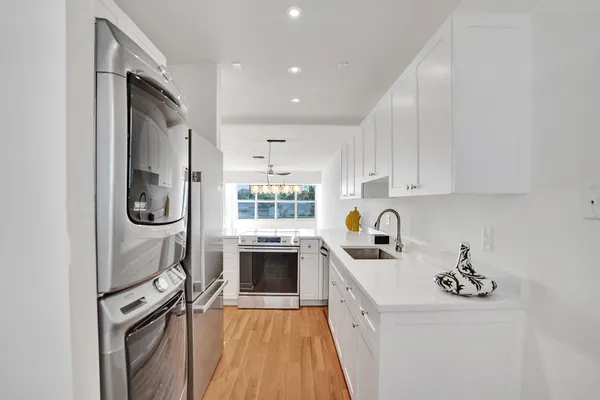 a kitchen with granite countertop a sink and stove top oven