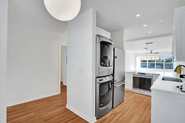 a view of kitchen with stainless steel appliances granite countertop a stove and a wooden floors