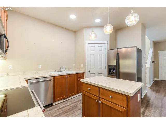 a kitchen with stainless steel appliances granite countertop a stove a sink dishwasher and a microwave oven with cabinets