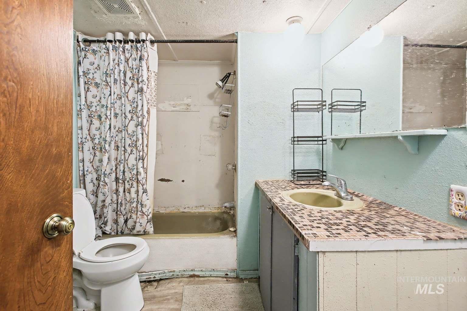 628 Burrell Avenue, Unit 5 Lewiston, ID 83501 - Photo 13 of 15 Bathroom with vanity, shower / tub combo, and a textured ceiling