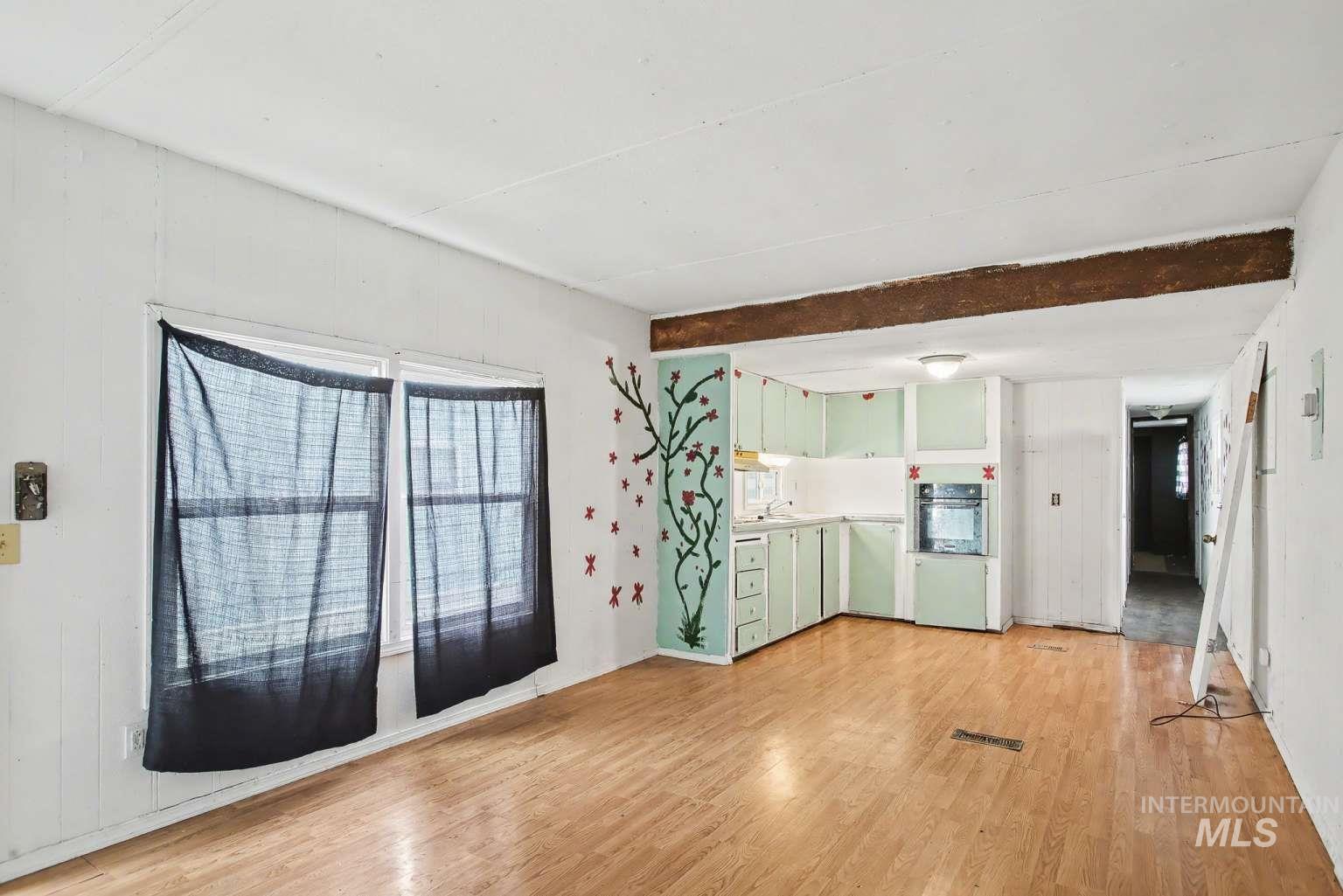 628 Burrell Avenue, Unit 5 Lewiston, ID 83501 - Photo 2 of 15 Unfurnished living room with light wood-style flooring and beam ceiling