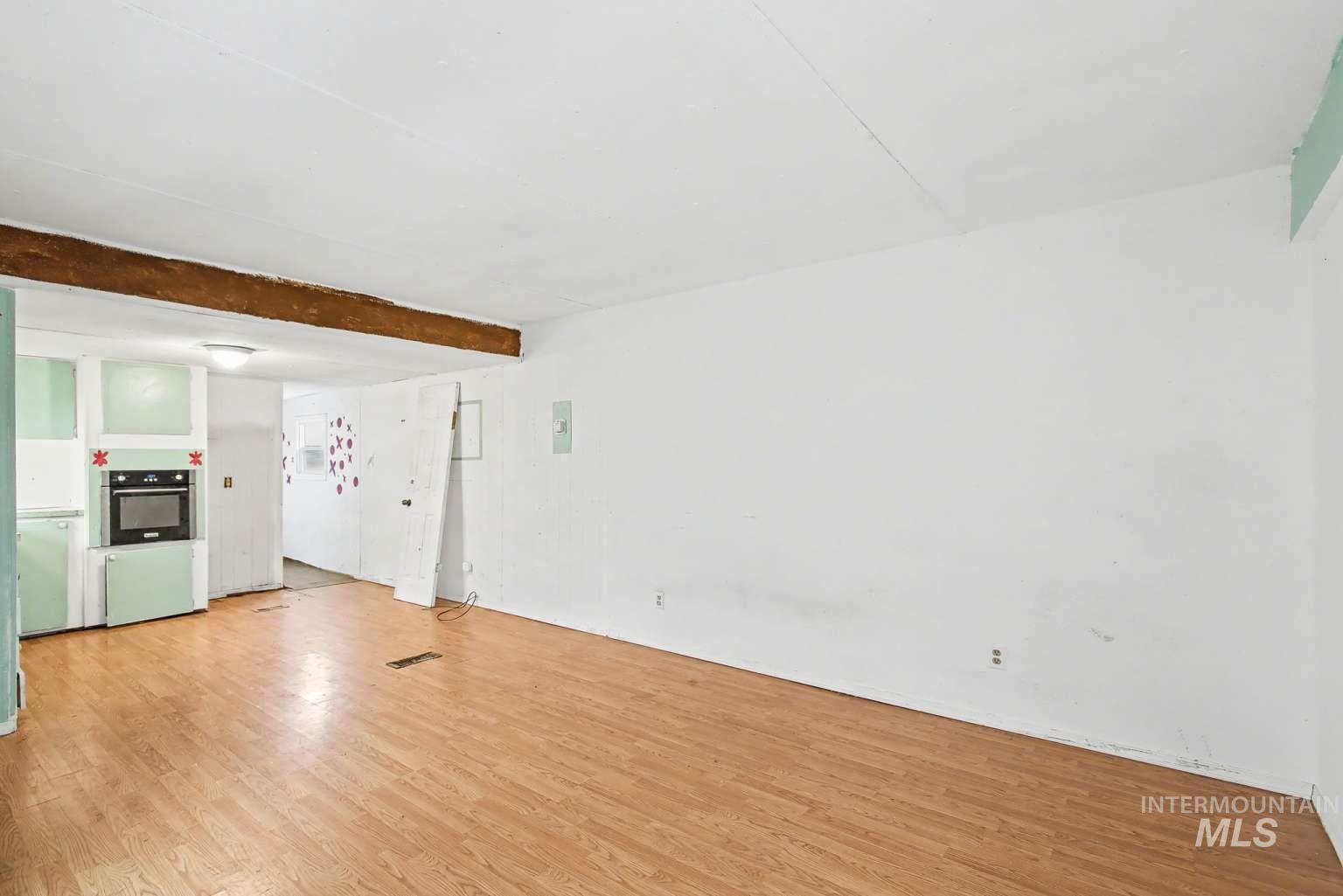 628 Burrell Avenue, Unit 5 Lewiston, ID 83501 - Photo 4 of 15 Unfurnished living room featuring light wood finished floors and beamed ceiling