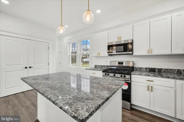 a kitchen with stainless steel appliances granite countertop a granite counter tops and white cabinets