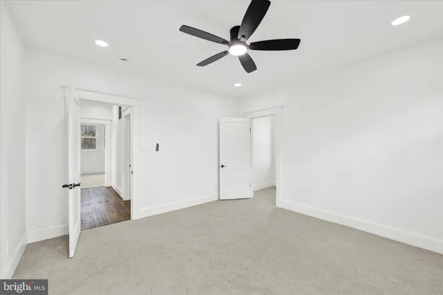 an empty room with ceiling fan and window
