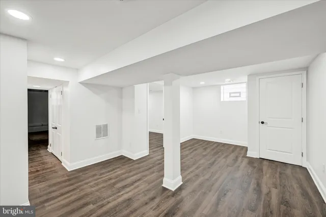 a view of an empty room with wooden floor