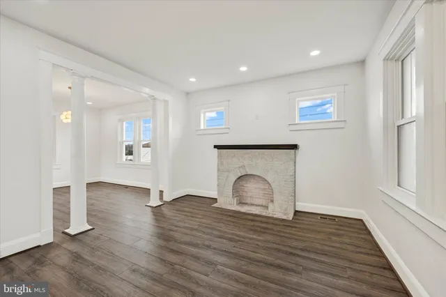 a view of empty room with wooden floor and fireplace