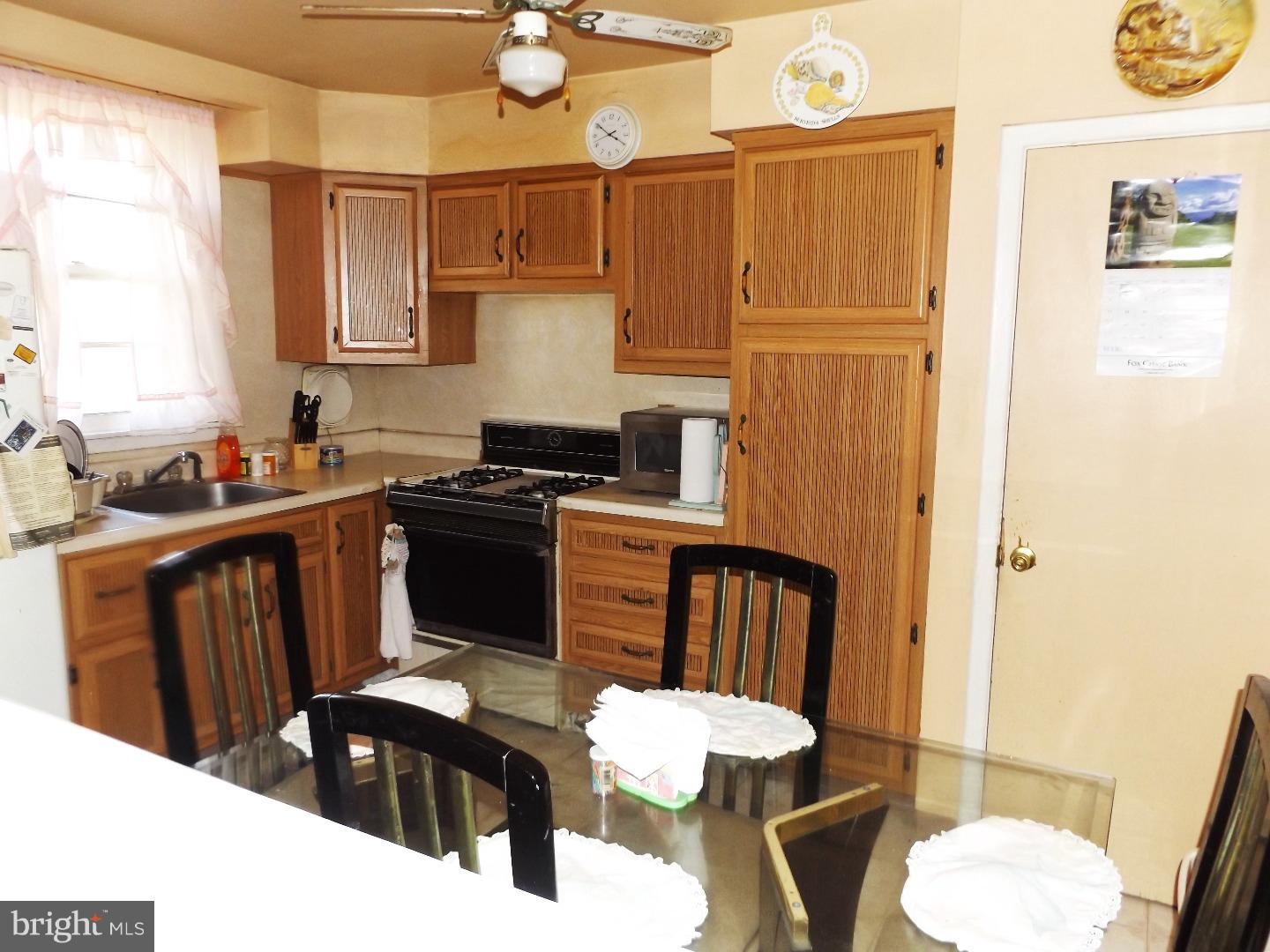 971 Victoria Road Warminster, PA 18974 - Photo 7 of 15 a kitchen with a sink a stove cabinets and a dining table