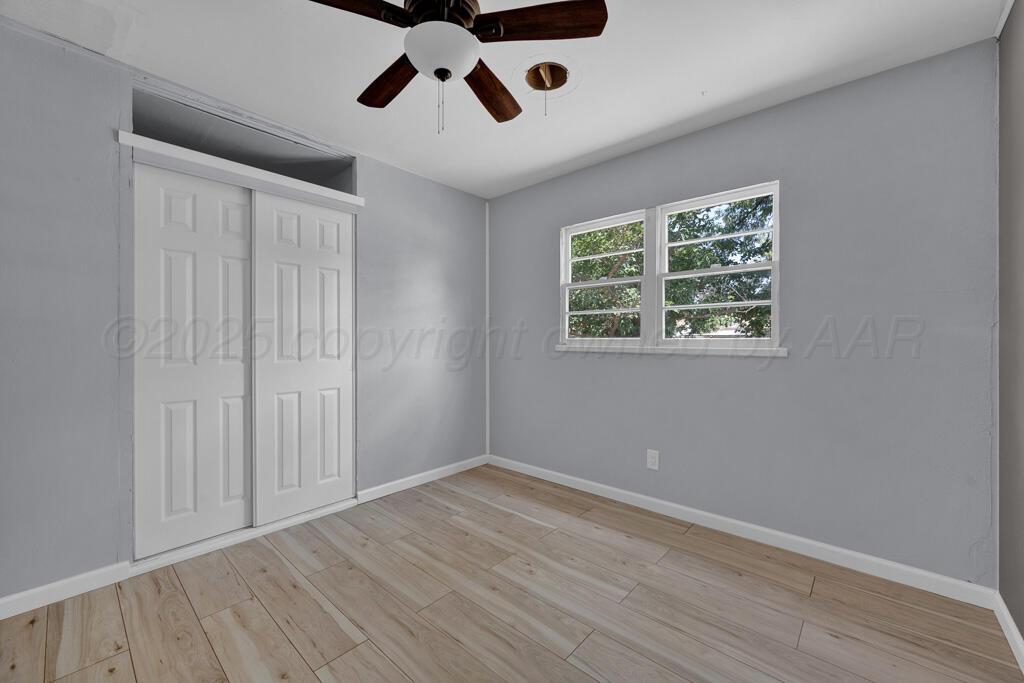 5122 Crockett Street Amarillo, TX 79110 - Photo 11 of 17 a view of an empty room with wooden floor and a window