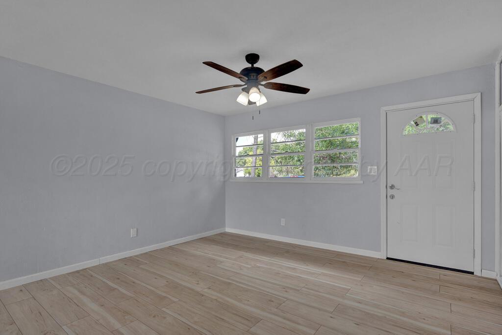 5122 Crockett Street Amarillo, TX 79110 - Photo 5 of 17 an empty room with wooden floor and windows