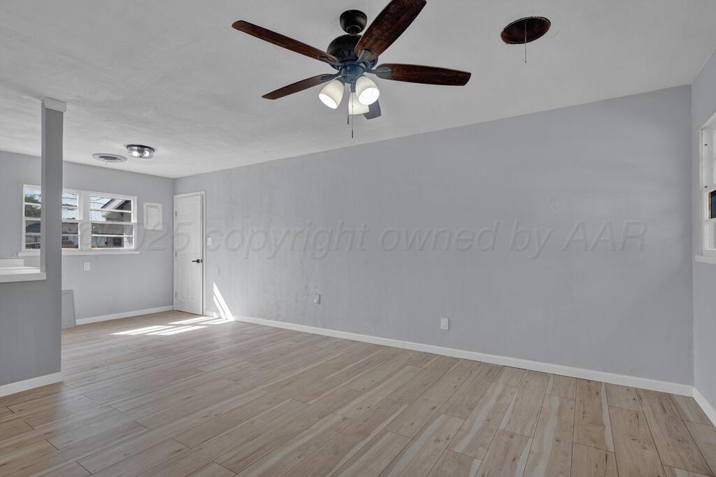 5122 Crockett Street Amarillo, TX 79110 - Photo 6 of 17 wooden floor in an empty room with a window