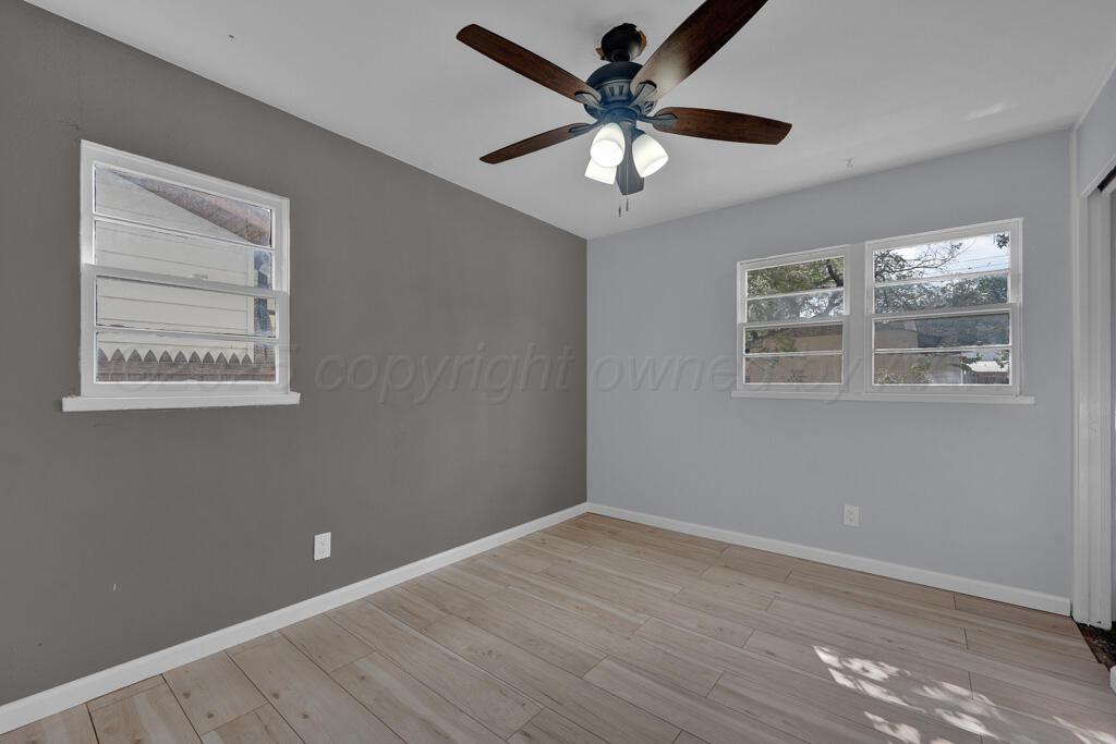 5122 Crockett Street Amarillo, TX 79110 - Photo 7 of 17 a view of an empty room with wooden floor and a ceiling fan