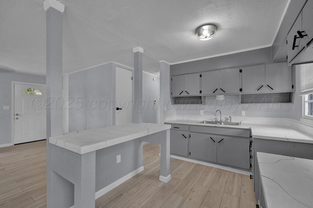 5122 Crockett Street Amarillo, TX 79110 - Photo 8 of 17 a kitchen with sink cabinets and wooden floor